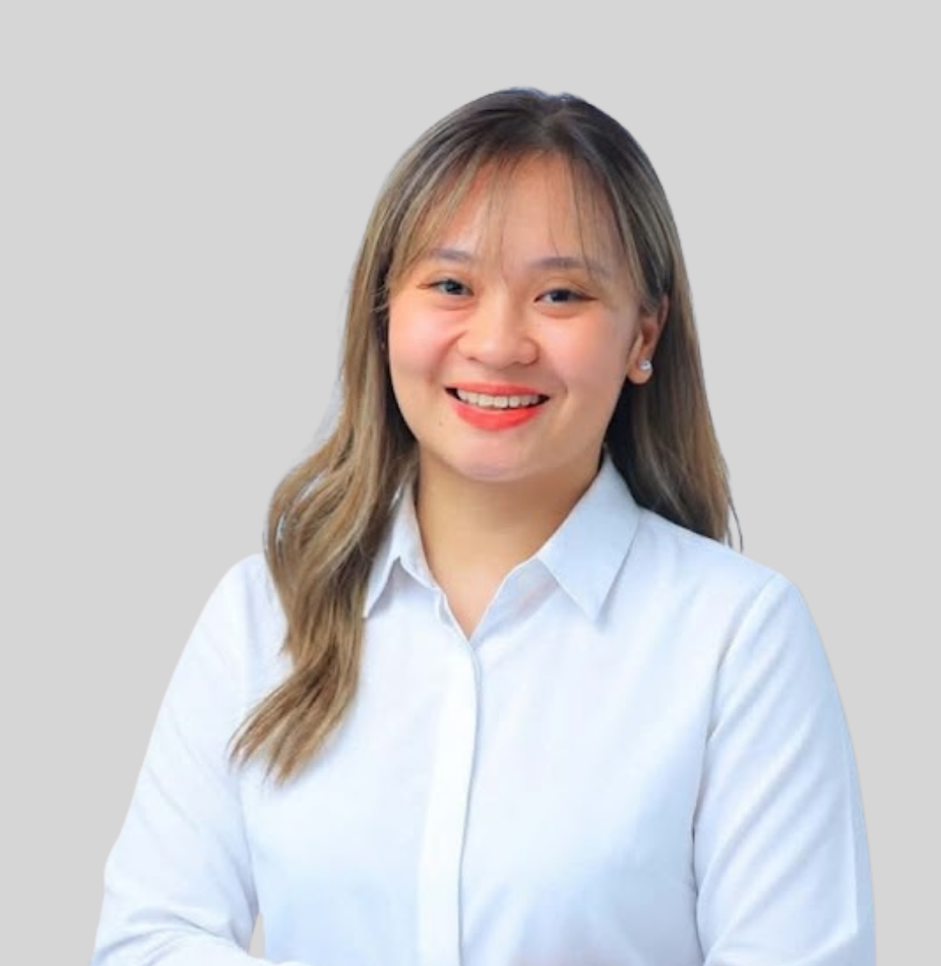 Professional portrait of a smiling woman with long hair, wearing a light blue blouse, against a neutral gray background.