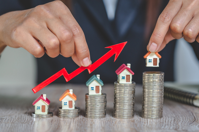 Businessman Holding Graph Over The Increasing House Miniature, Real estate investment,investment mortgage finance and home loan business, growth and money.